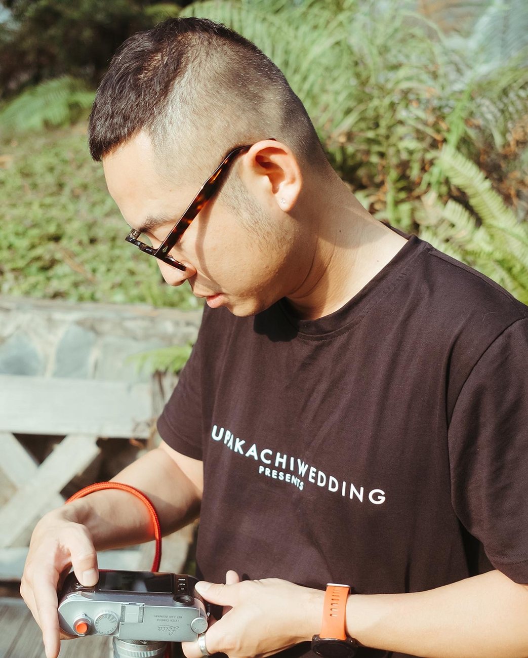Cường checking his camera in a Nupakachi Wedding t-shirt