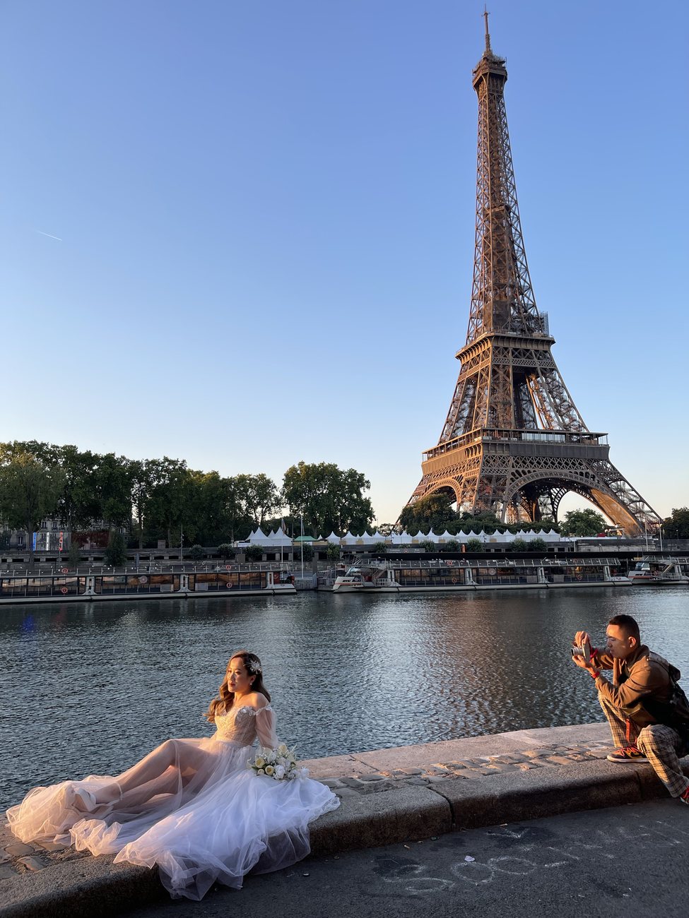 Cường photographing a bride by the Seine with the Eiffel Tower behind