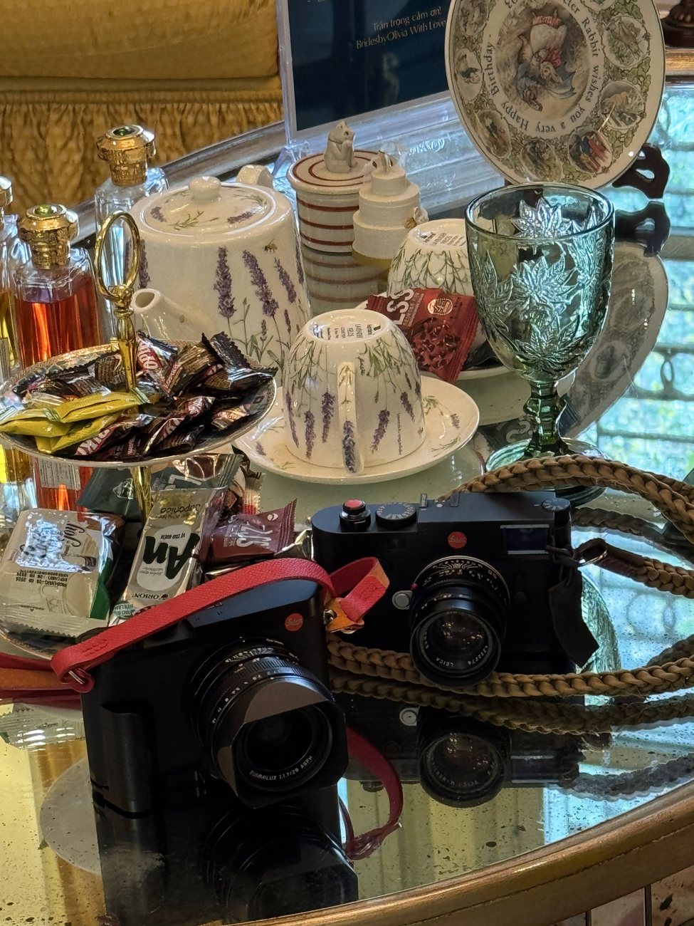 Leica camera resting on a vintage table with tea set