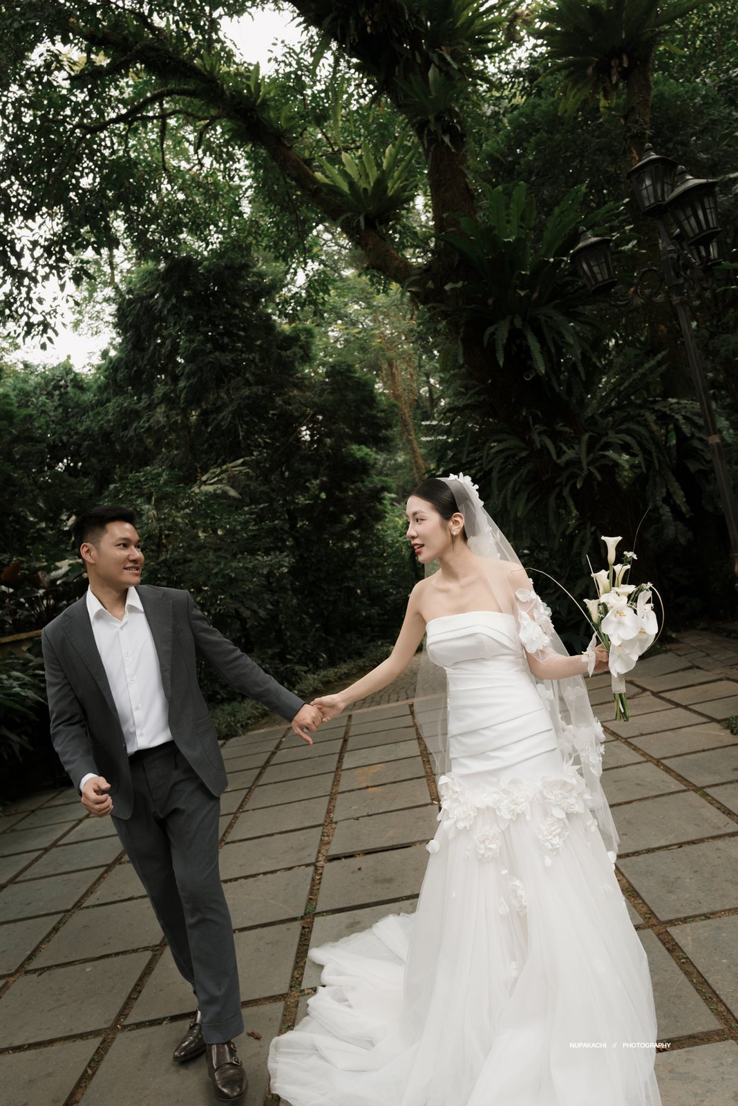 Cặp đôi nắm tay bước trên sân đá, chụp ảnh cưới Ba Vì