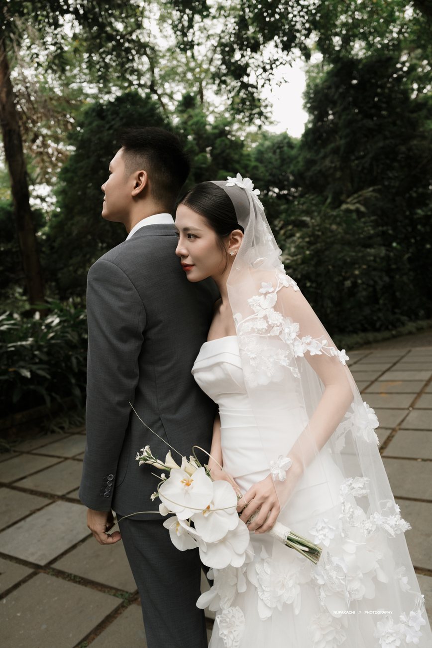 Cô dâu cầm hoa trên vai chú rể, rừng quốc gia Ba Vì