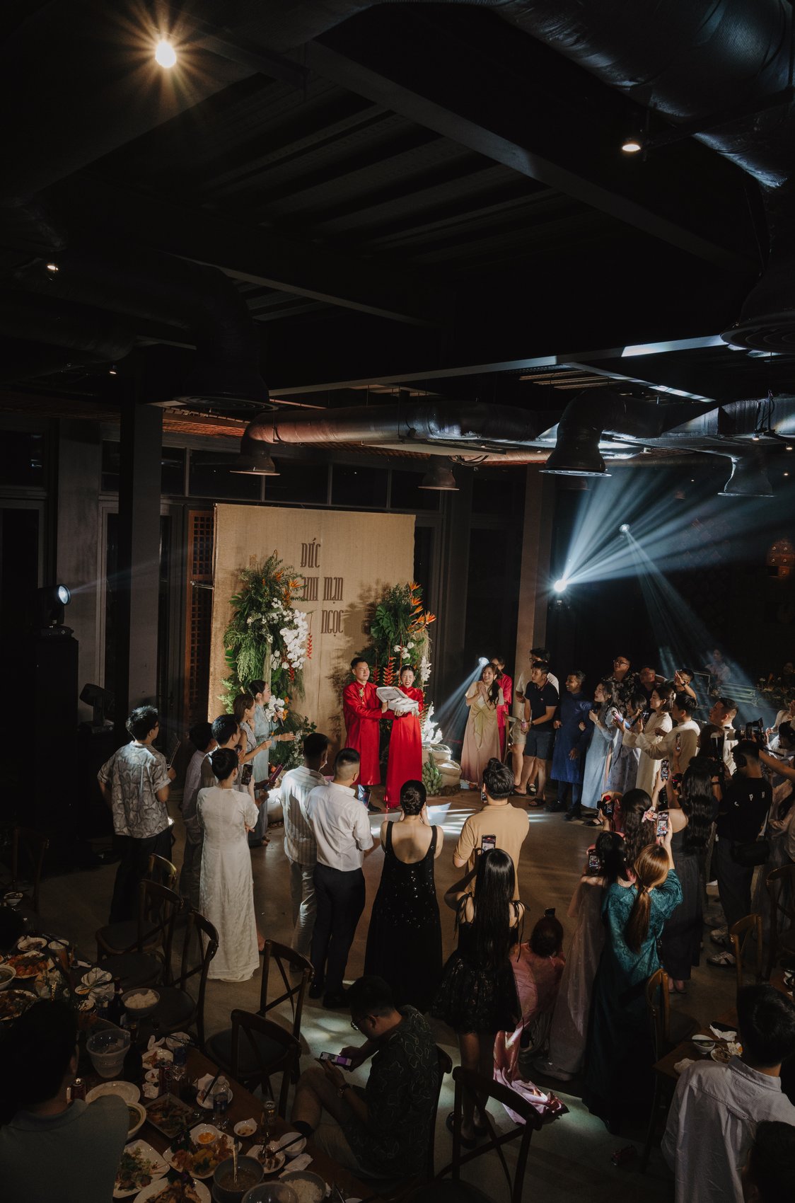 Destination wedding reception stage with light beams and floral backdrop, Vietnam