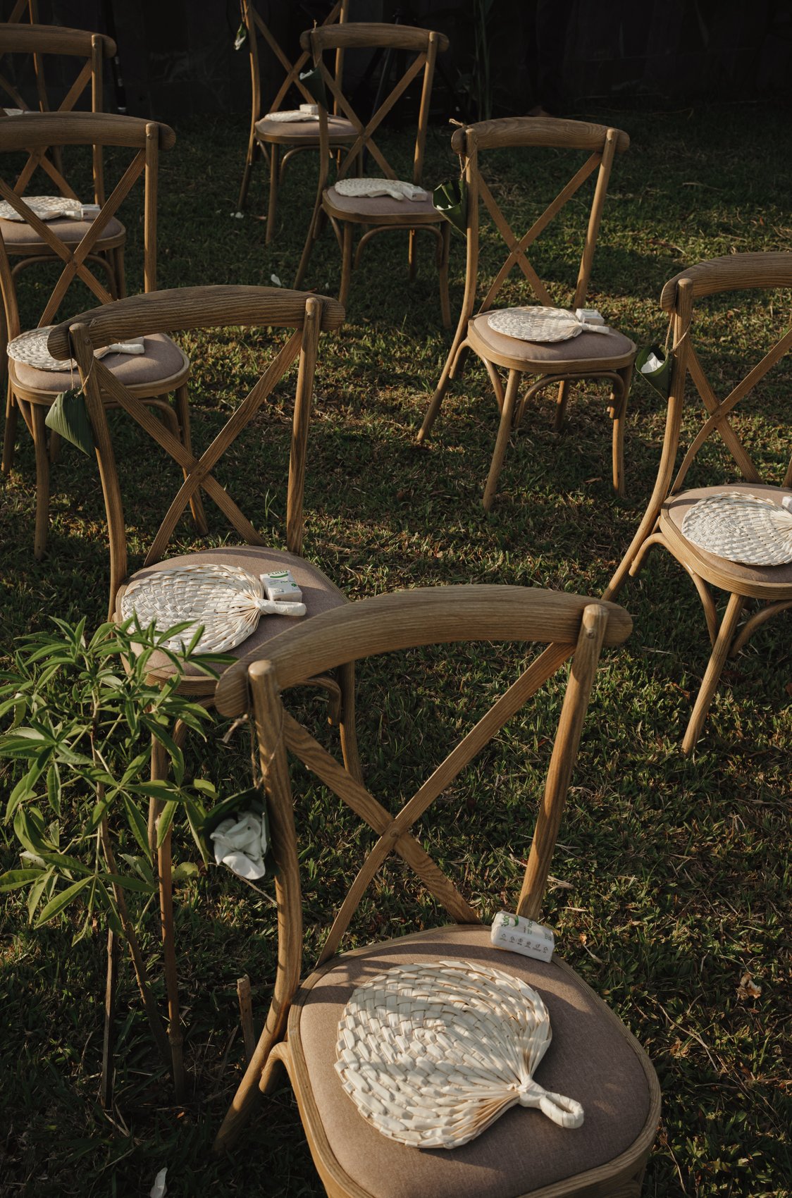 Wooden ceremony chairs on the lawn at an outdoor destination wedding, Vietnam