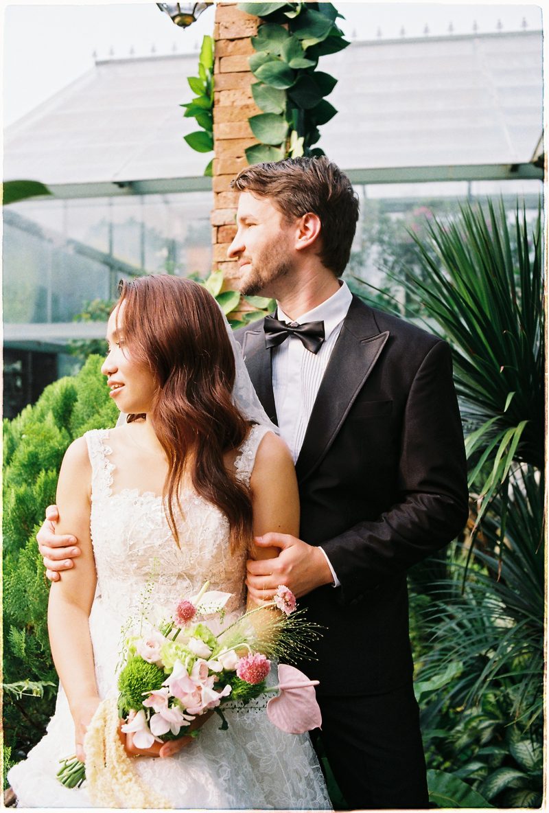 Bride and groom in a topiary garden and glasshouse on 35mm film (frame 5 of 12)