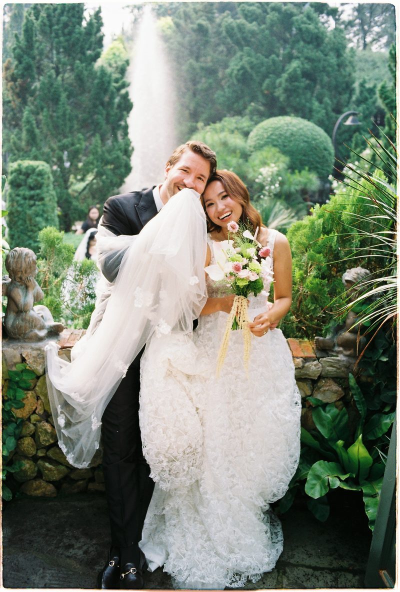 Bride and groom in a topiary garden and glasshouse on 35mm film (frame 11 of 12)