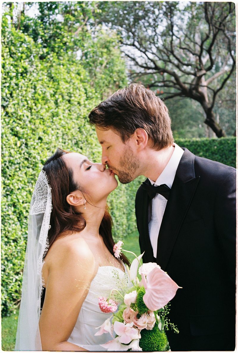 Bride and groom in a topiary garden and glasshouse on 35mm film (frame 8 of 12)