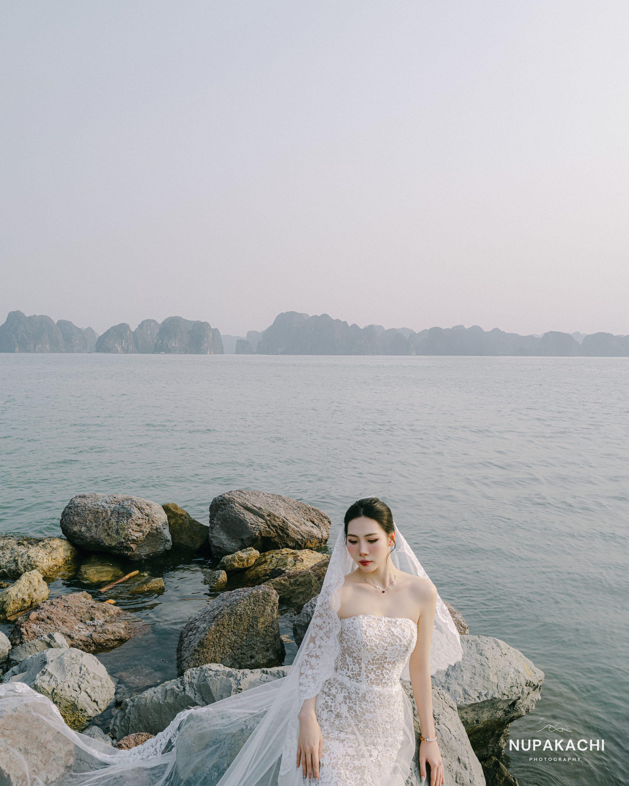 Cô dâu với tà voan dài trên đá ven vịnh Hạ Long