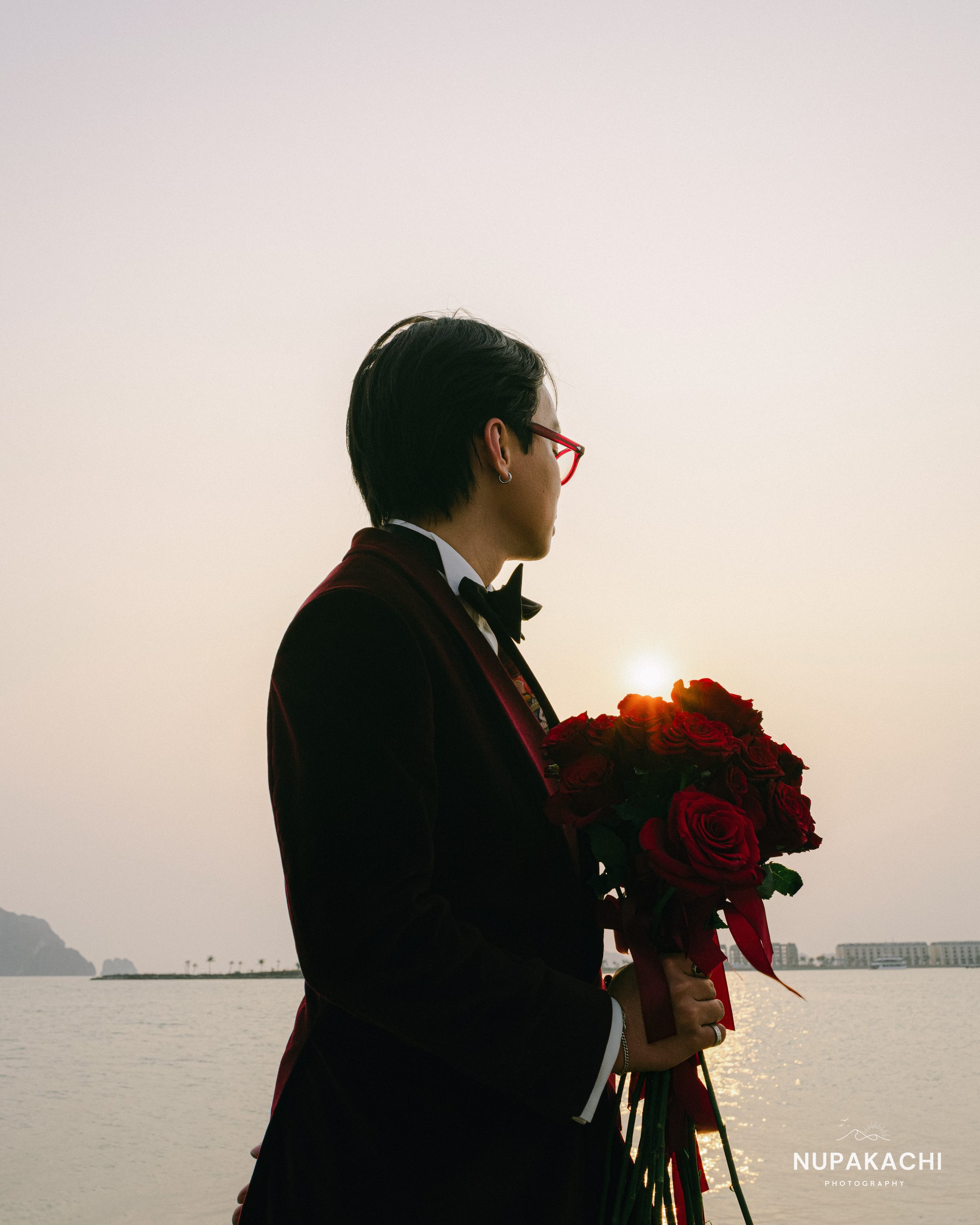 Chú rể cầm hoa đỏ ngược nắng hoàng hôn Hạ Long