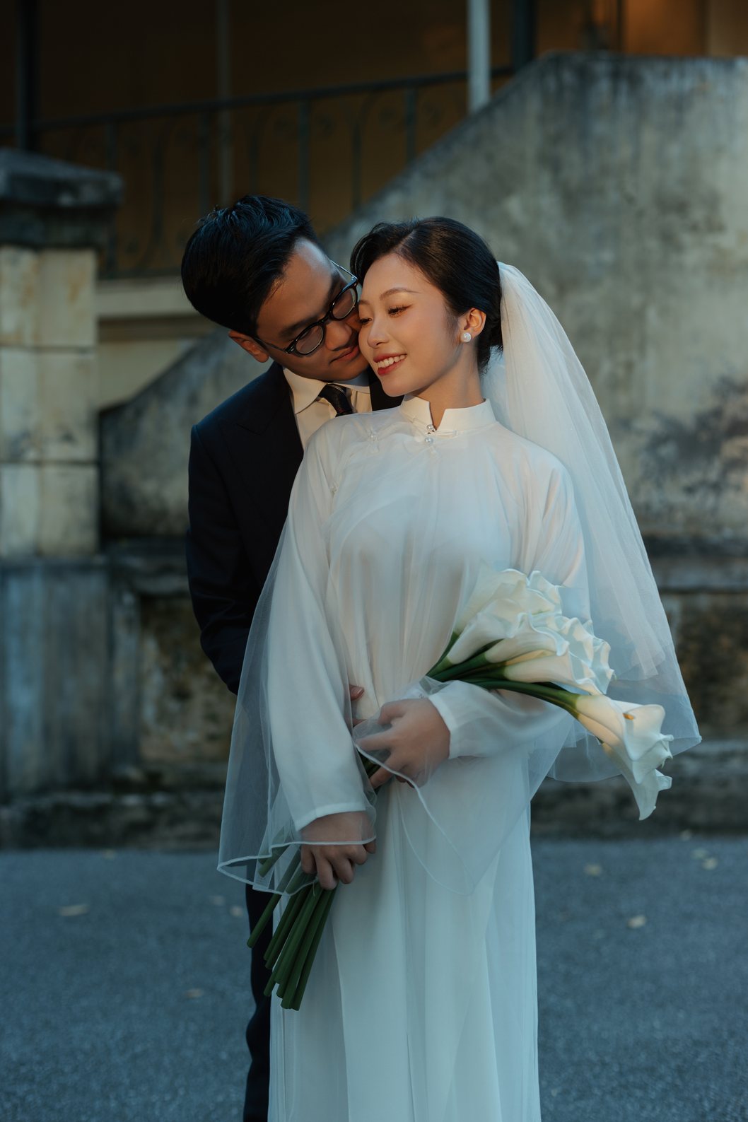 Chú rể chỉnh khăn voan cho cô dâu bên hành lang cột, prewedding Hà Nội