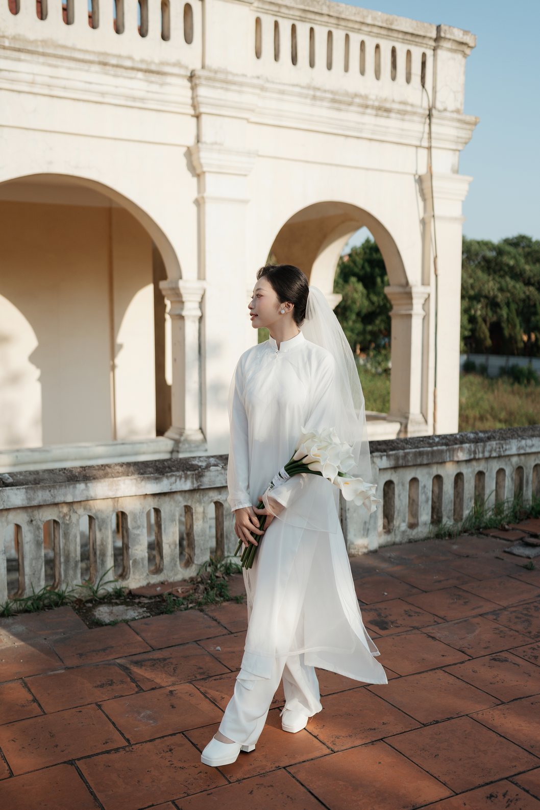 Cặp đôi nắm tay đi trên sân gạch Hoàng Thành Thăng Long
