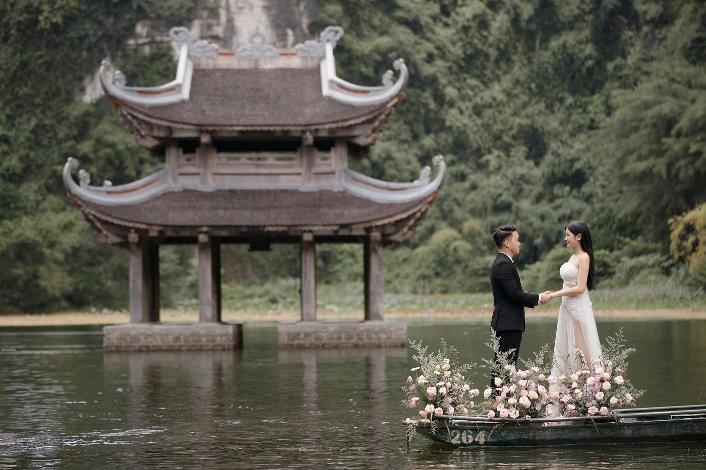 Thủy đình Tràng An giữa mặt hồ, cặp đôi trên thuyền kết hoa