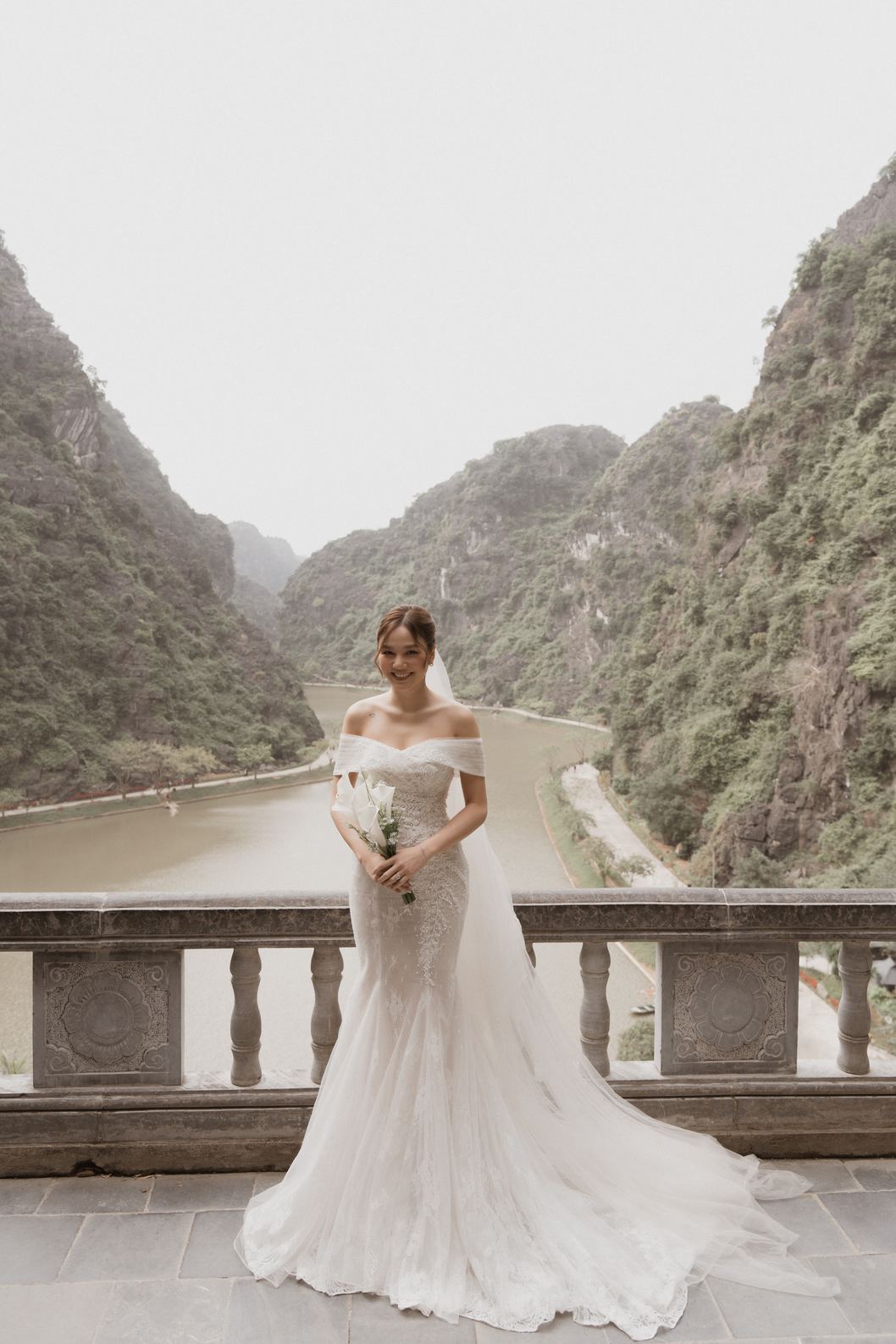 Cô dâu bên lan can đá nhìn xuống dòng sông giữa núi đá Ninh Bình