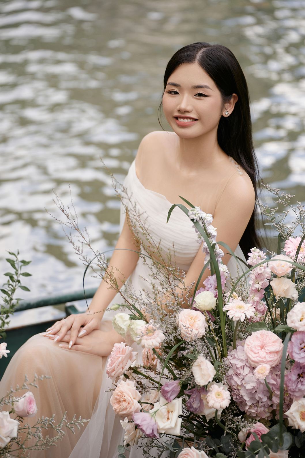 Cô dâu cười giữa thuyền hoa hồng phấn trên sông Tràng An