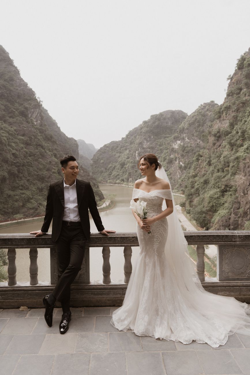 Cặp đôi bên lan can đá nhìn xuống thung lũng núi đá Ninh Bình