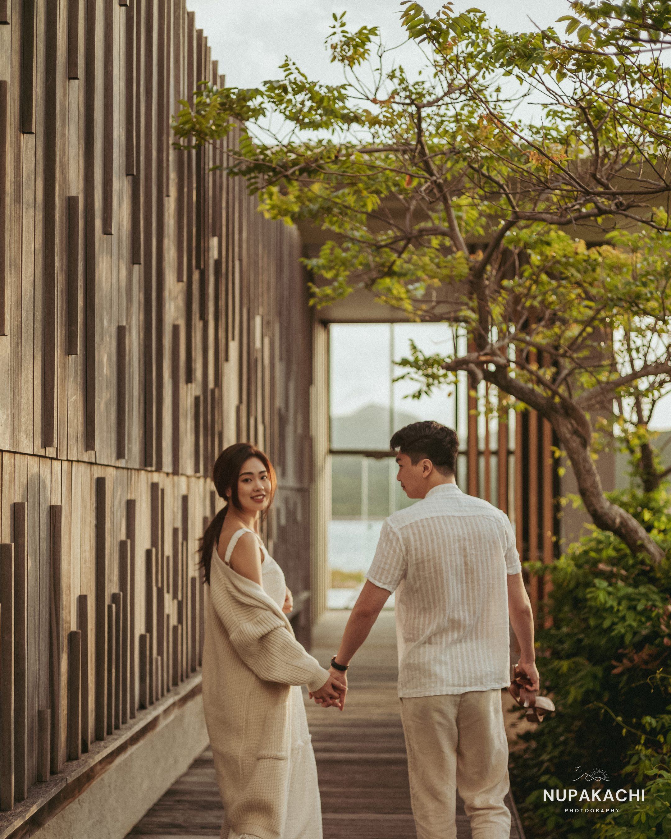 Cặp đôi dạo bước trên lối gỗ giữa kiến trúc resort Nha Trang