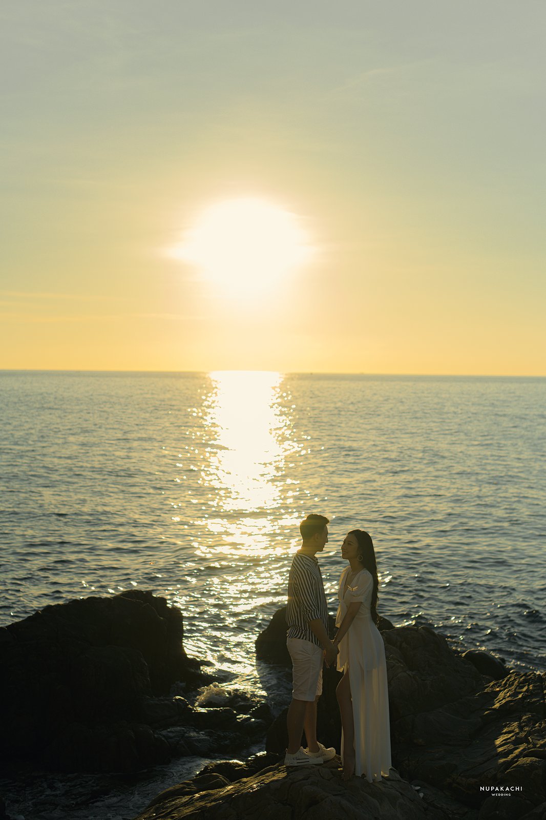 Sunset silhouette of a couple by the sea, destination pre-wedding Vietnam