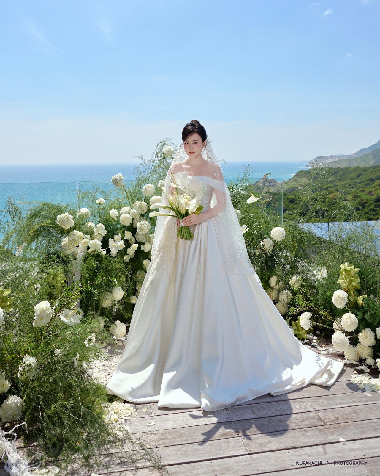 Bride with flowing veil and bouquet on a garden path, Vietnam pre-wedding