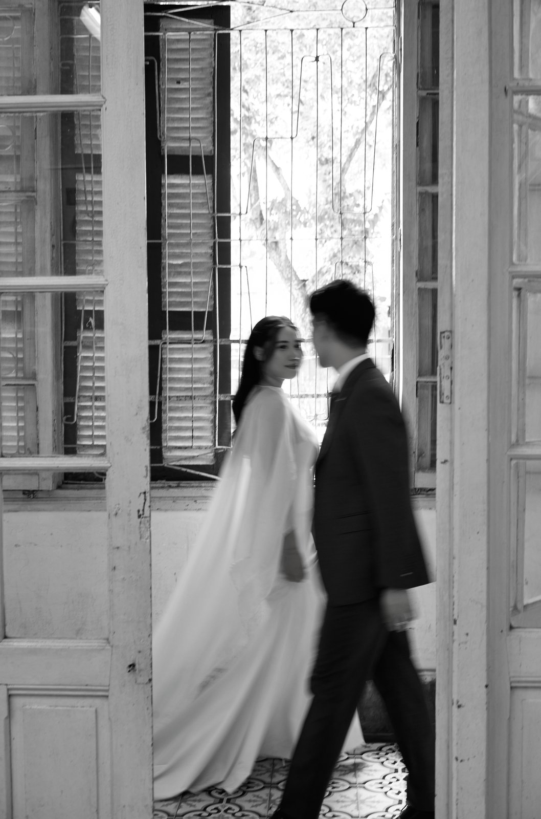 Black and white editorial pre-wedding portrait in a heritage doorway, Vietnam