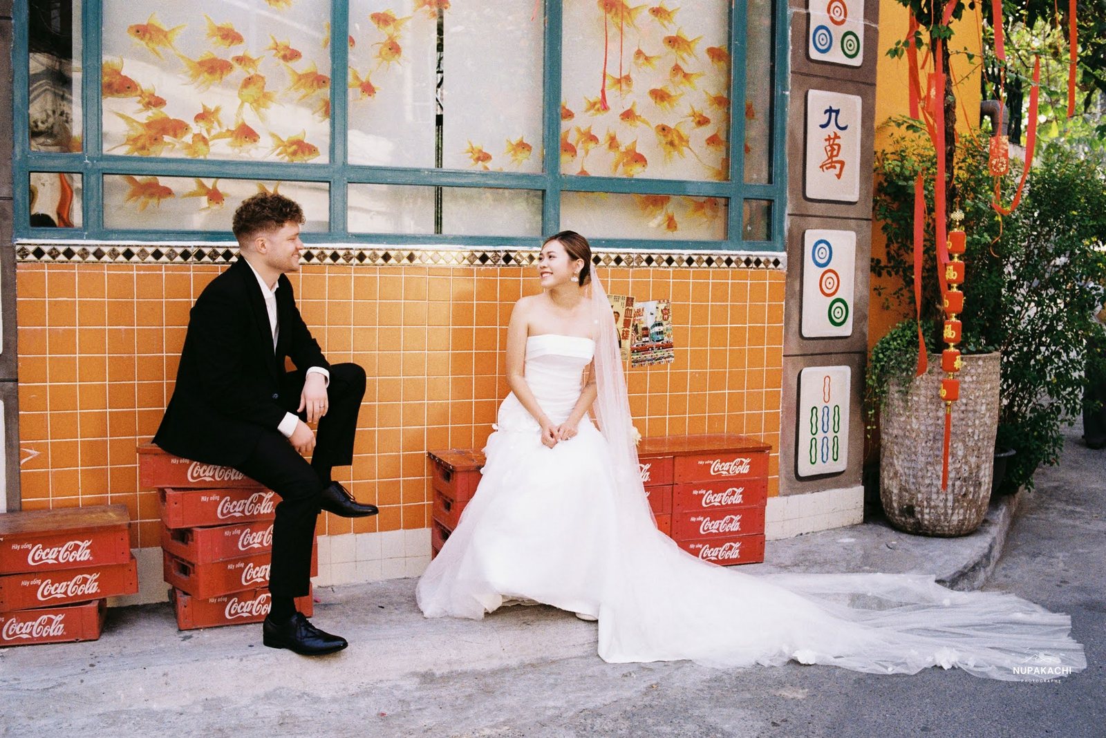 An orange tiled café wall, mahjong tile signs and Coca-Cola crates