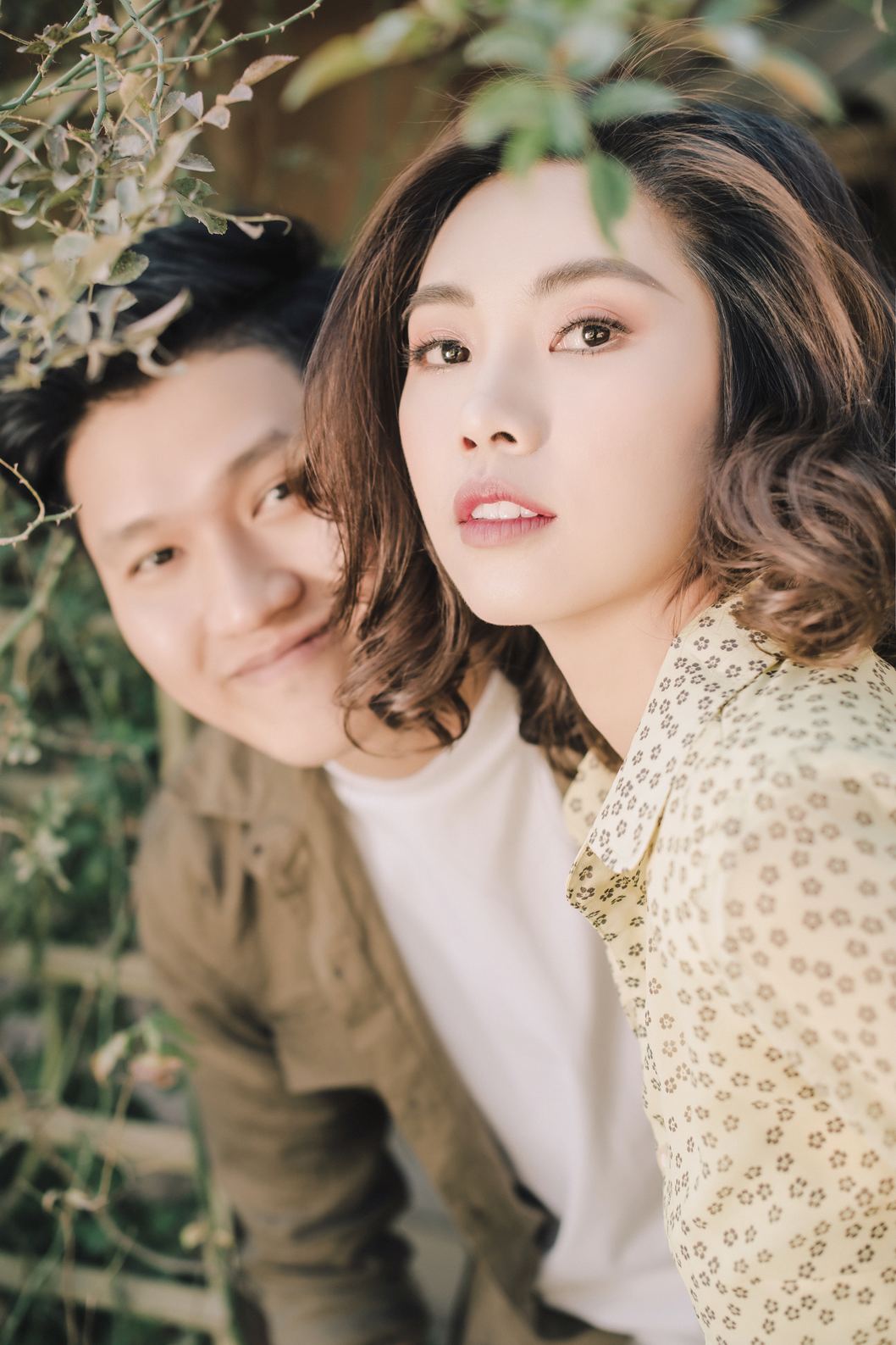 Cận cảnh cặp đôi trong trang phục vàng bên bụi cây, prewedding Sapa