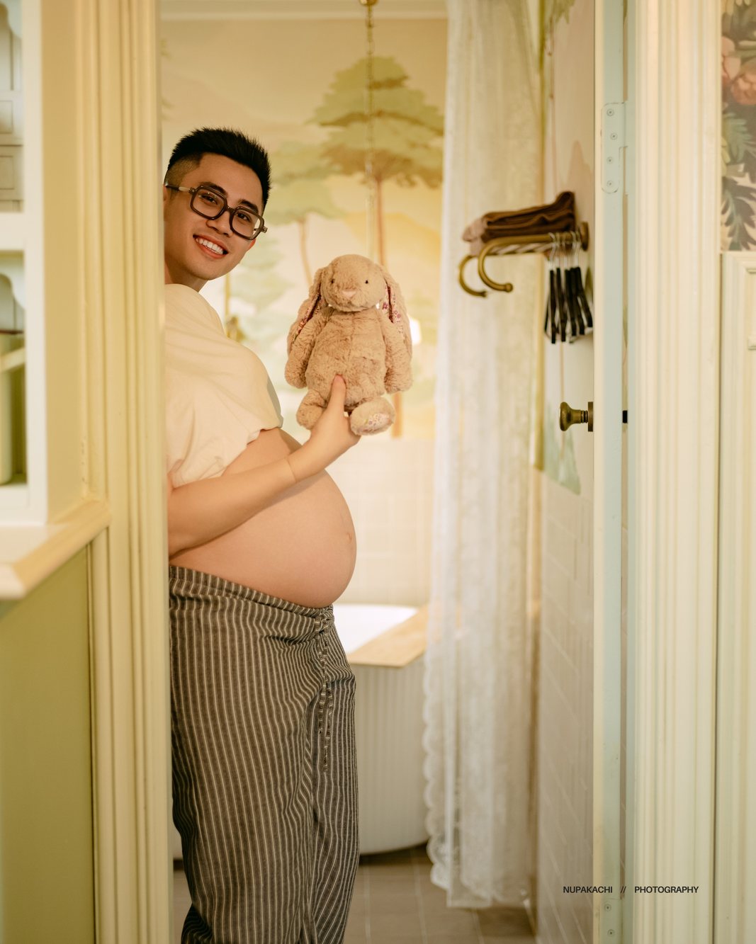 Expecting mother holding a bunny toy by the doorway, maternity photography Vietnam