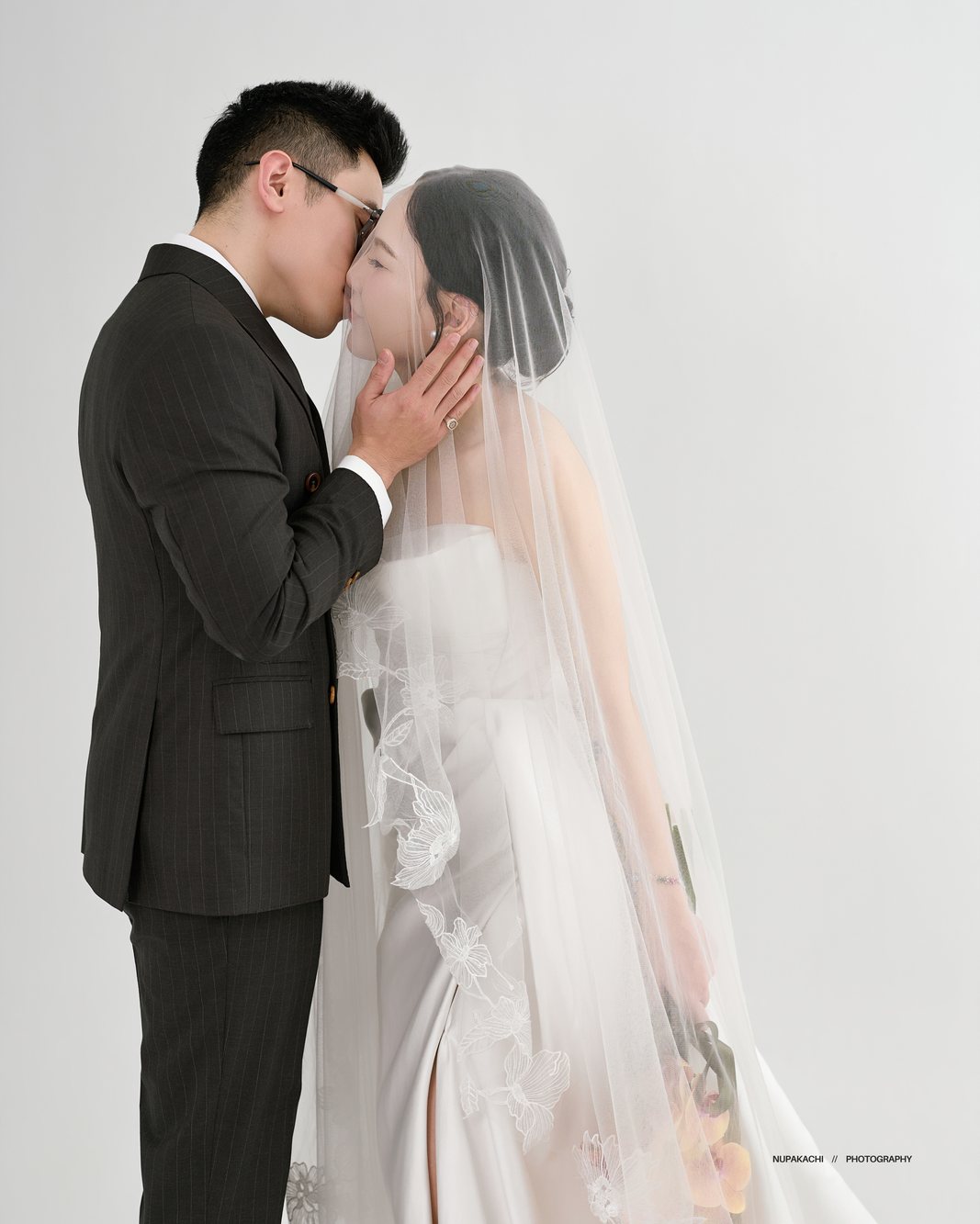 Groom kissing his bride through the lace veil, fine art wedding photography Hanoi