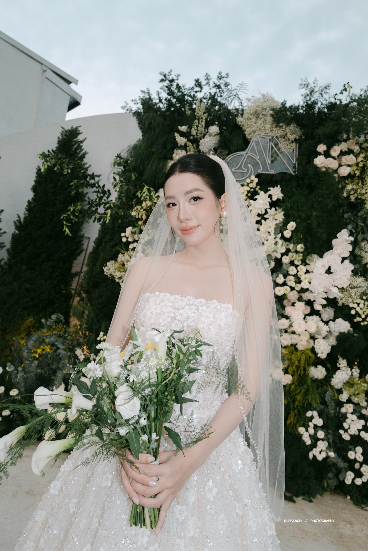 Bride with wildflower bouquet at a garden wedding ceremony photographed by Nupakachi Vietnam