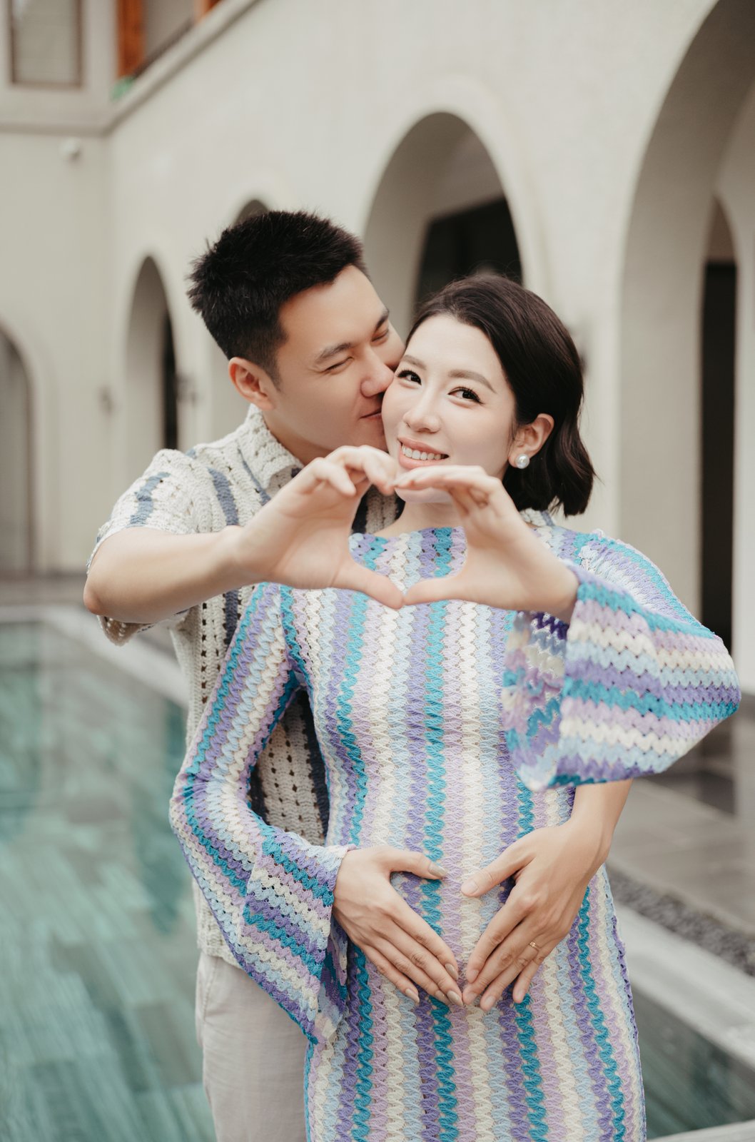Hands making a heart over the baby bump, maternity photography by Nupakachi