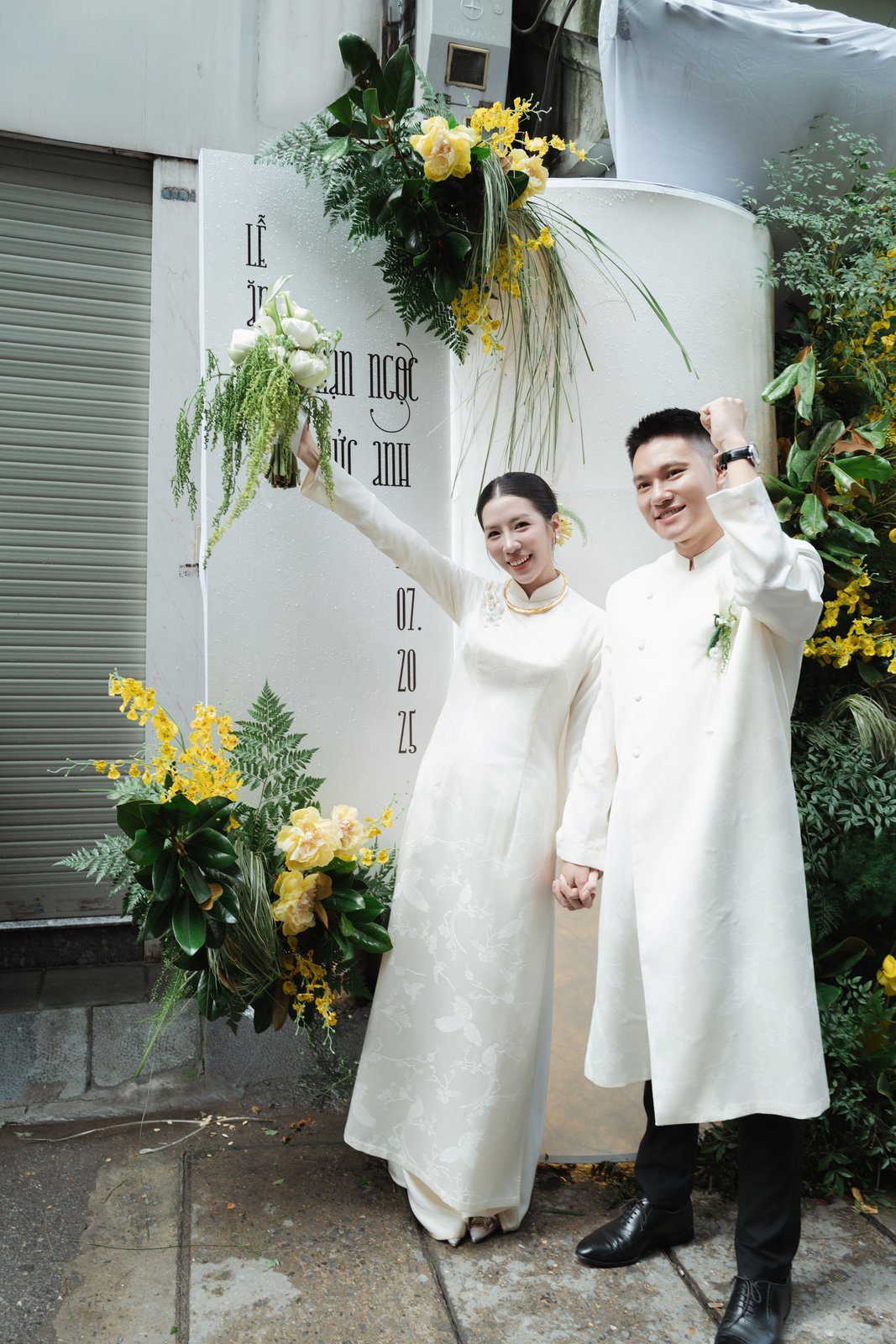 Groom and bride in white ao dai at their traditional Vietnamese wedding ceremony