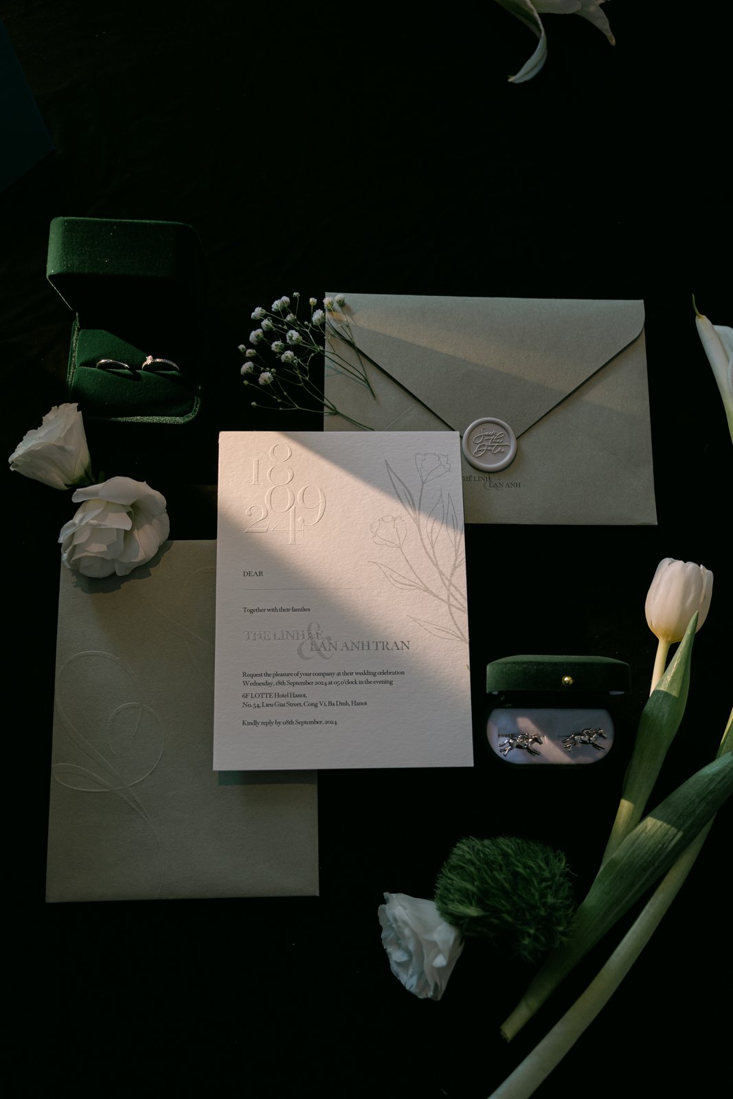 Wedding invitation suite and rings in moody light, fine wedding stationery details