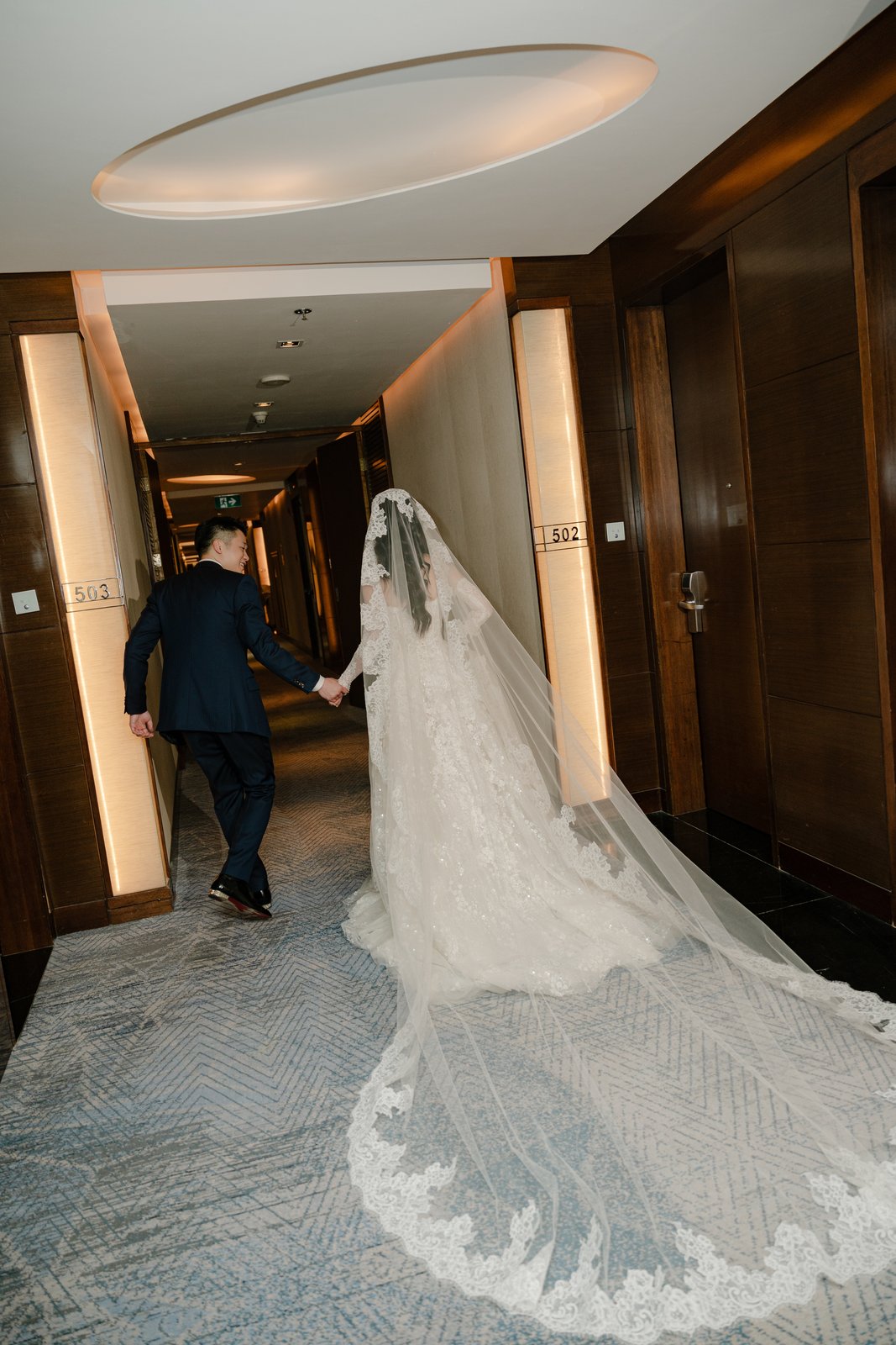 Cathedral length veil trailing down a hotel corridor on the wedding day