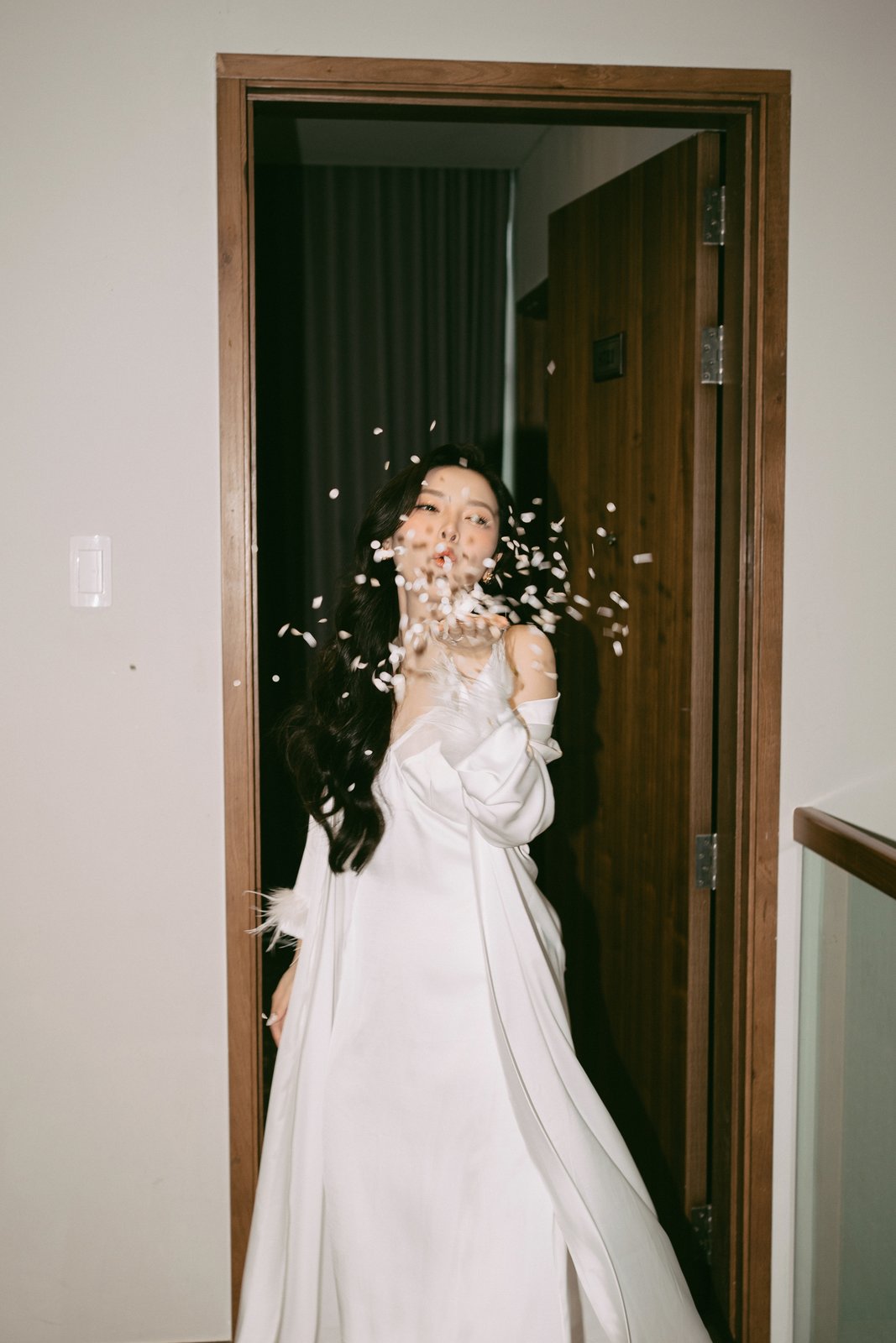 Bride with baby's breath in a doorway on the wedding morning, documentary photography Vietnam