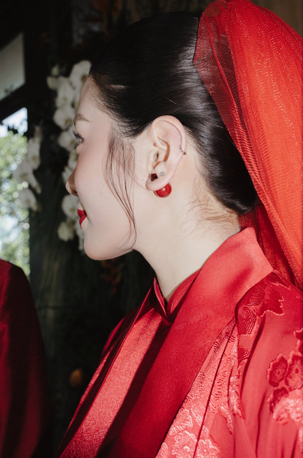 Bride in red traditional ao dai with veil, Vietnamese wedding ceremony detail