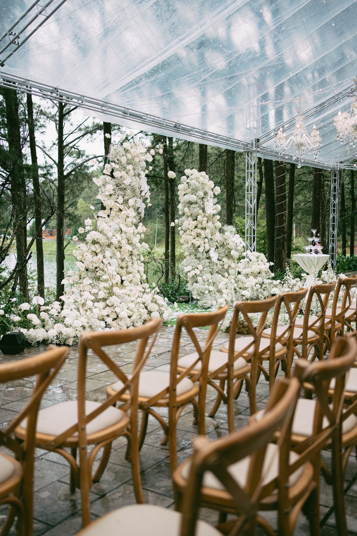 Wedding ceremony aisle inside a glass marquee among pine trees, documentary wedding photography Vietnam
