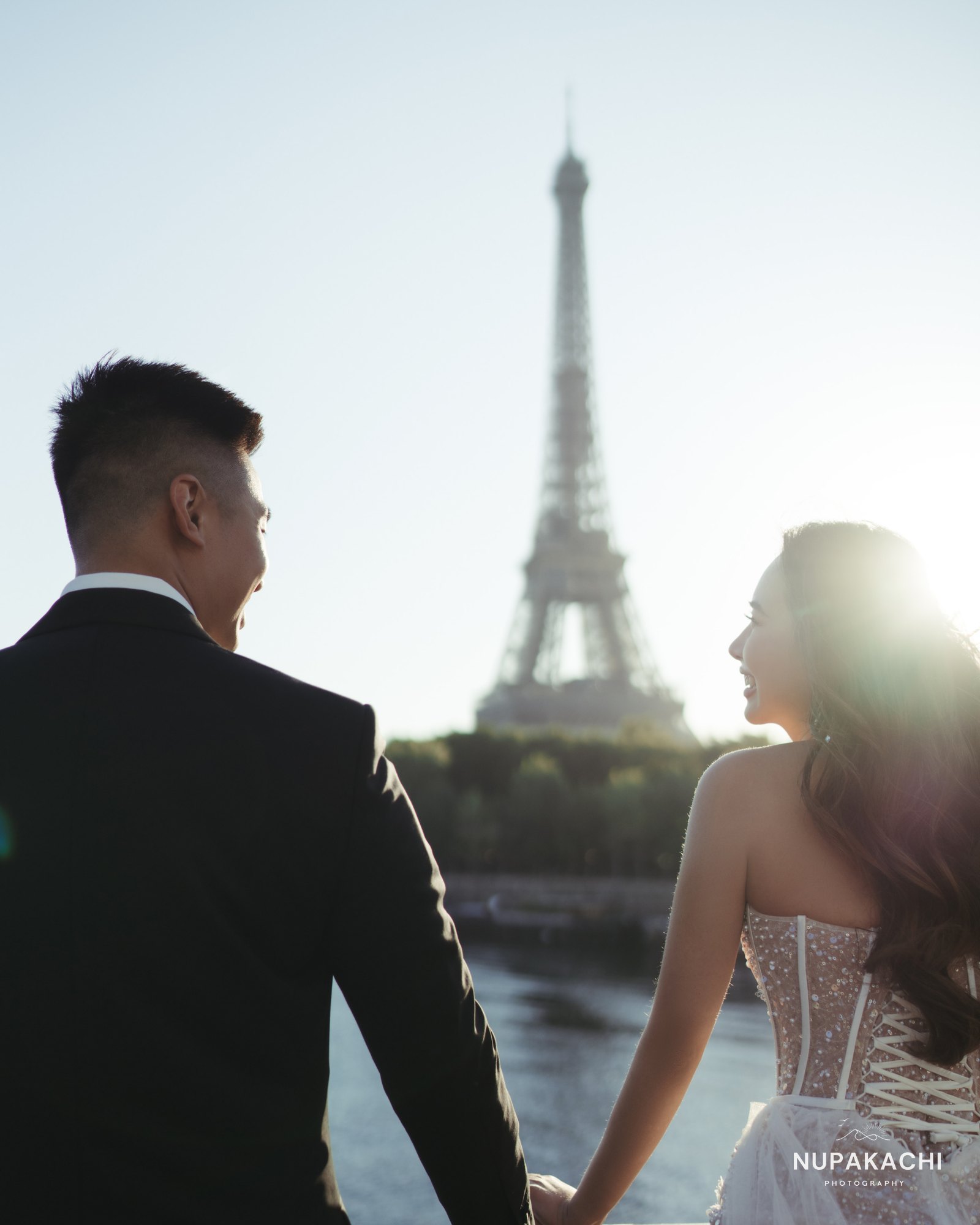 Couple holding hands by the Seine with the Eiffel Tower behind, Paris wedding photography