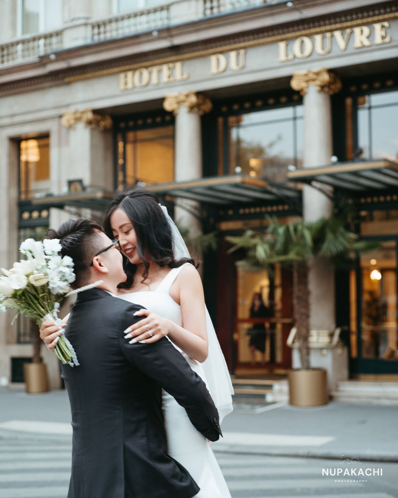 Embrace outside Hotel du Louvre, Paris destination pre-wedding