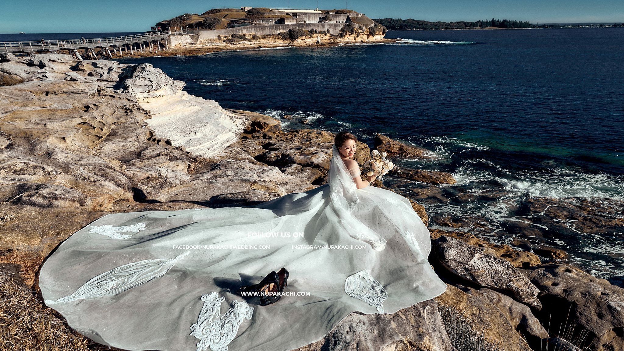 Wedding gown train over the sea cliffs of Sydney, world wide destination photography by Nupakachi
