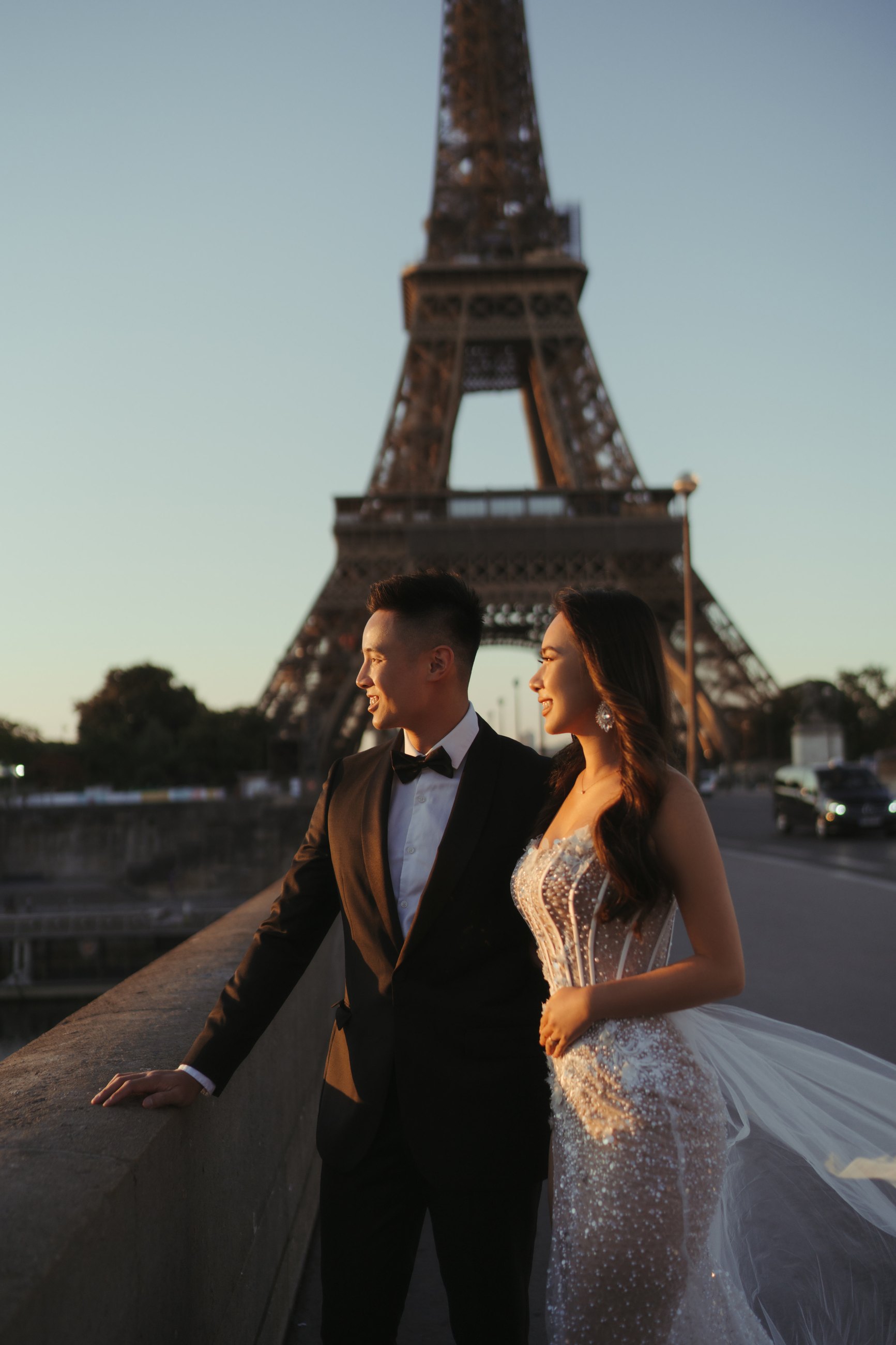 Bride and groom at the Eiffel Tower at dusk, destination wedding photography in Paris by Nupakachi