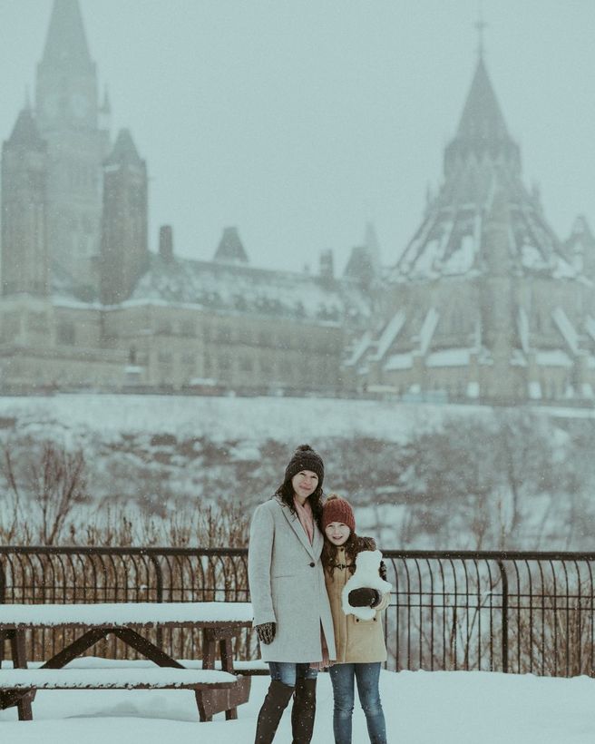 Gia đình đứng trong tuyết trước toà nhà Quốc hội Ottawa, Canada