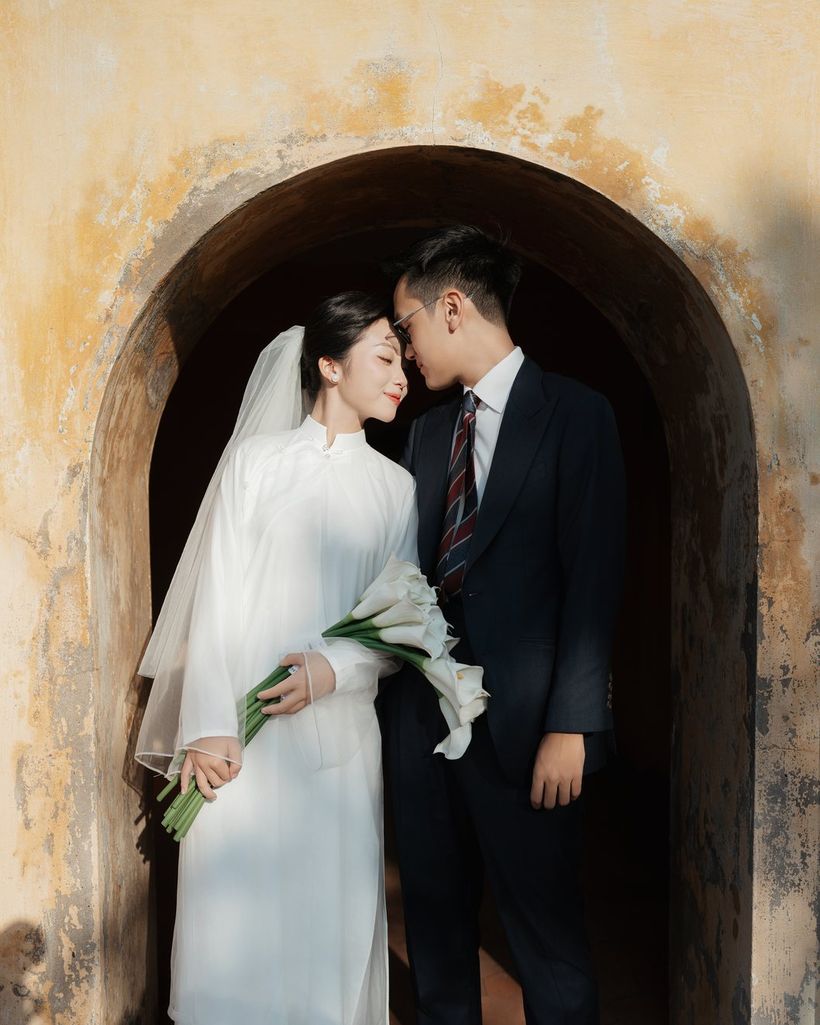 Cặp đôi áo dài trắng trong cổng vòm Hoàng thành Thăng Long, Hà Nội